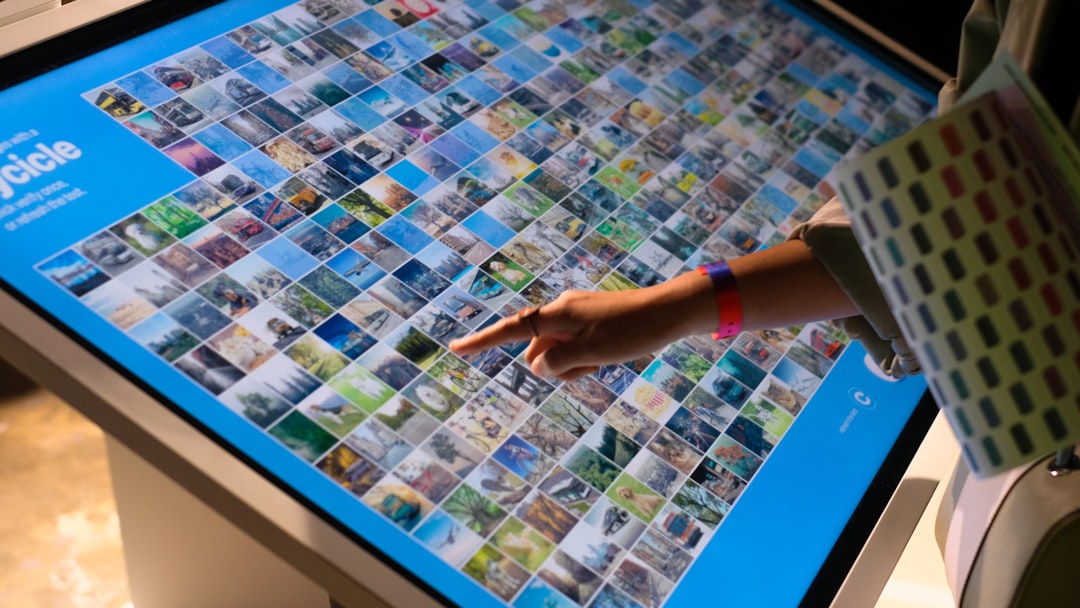 a-person-pointing-at-a-large-display-of-pictures-9d6ulcw38ss